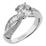 This split shank twist engagement ring takes a round center, and has a line of tapered baguettes 0.34 ctw., accented with .21 ctw RD pave diamonds
