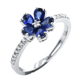 This delicate right hand ring has a flower design with petals of pear-shaped sapphires 1.06 ctw., with a diamond center and shank 0.13 ctw.