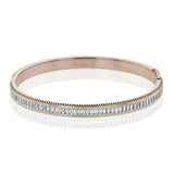 A striking 18K bangle in two-tone gold with a row of baguette diamonds 2.0 ctw. set in white gold, with a delicate ribbed edge