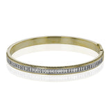 A striking 18K bangle in two-tone gold with a row of baguette diamonds 2.0 ctw. set in white gold, with a delicate ribbed edge