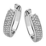 Our statement making oval diamond huggie earrings in 18K white gold, sparkle with 3 rows of diamonds and have a bar-snap closure
