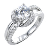 This 18K white gold engagement ring has a split shank design with RD diamonds 0.21 ctw. on one side and high polish on the other side, and a diamond halo with fine millgrain trim, of princess cut stones 0.33 ctw.