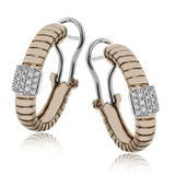 This elegant huggie earring in 18K yellow gold has a ribbed design and accented with 0.24 ctw. of pave set diamonds in white gold, and a lever back closure