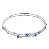 This whimsical bangle in 18K white gold features 1.80 ctw of bezel set diamonds, that appear to be suspended on a wire