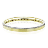 This stunning yellow gold bangle has a matte finish and is accented by a row of white diamonds 0.32 ctw., along its edge.