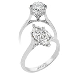 This elegant white gold engagement ring takes an marquise center and is adorned with a delicate under halo, and a line of diamonds on the side profile 0.13 ctw