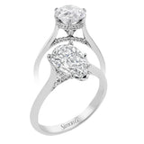 This elegant white gold engagement ring takes a pear shape center and is adorned with a delicate under halo, and a line of diamonds on the side profile 0.13 ctw