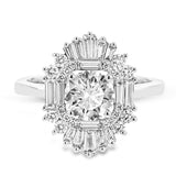 Crafted in 18K white gold, this distinctive ring is an ode to Art Deco design & features a halo of RD diamonds 0.23 ctw, surrounded by a burst of baguette shaped diamonds 0.70 ctw.