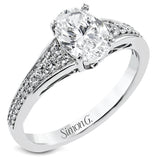 This white gold engagement ring takes an oval center stone and has a tapered shank, with diamonds .22 ctw graduating in size down the sides. On the profile there is hand carved filligree design.