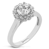 An 18k engagement ring with a new take on the classic solitaire design, features a twisted diamond halo 0.31 ctw., and high polished yellow band