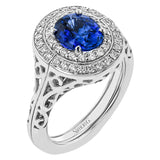 This 18 kt. ring stuns with an oval sapphire center 1.65 ctw., and has a double halo of diamonds totaling 0.62 ctw. set on a beautifully sculpted band