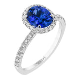 This 18 kt. ring stuns with an oval sapphire center 1.65 ctw., and has a double halo of diamonds totaling 0.62 ctw. set on a beautifully sculpted band