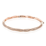 This modern rose gold bangle has a distinctive twisting design set with 1.68 ctw of white diamonds.