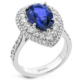 This beautiful right-hand ring in 18K white gold features a 5.0 ct. pear shaped sapphire, surrounded by a double halo of white diamonds & with diamonds half way down the sides 1.26 ctw.
