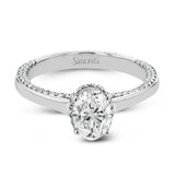 This engagement ring is made from an oval center stone and features a low halo as well as diamonds extended down the sides of the ring.