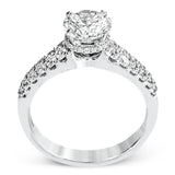 Shining white diamonds encircle the center stone in this Underhalo engagement ring, while also extending across the sides of the ring to ensure it glitters from all directions.