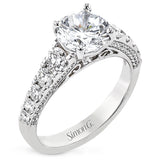 Filigree details underneath the center stone and diamonds that extend down the sides of this ring make it far from ordinary.