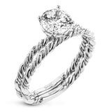 Two tones of 18k gold twist around each other in this contemporary yet timeless engagement ring.