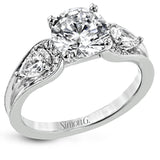 This modern 3 stone engagement ring takes a Round center and is flanked by 2 pear shaped diamonds 0.36 ctw., and 0.06 ctw of round diamonds