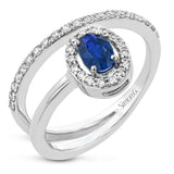 An oval shaped blue sapphire is the star of this 18k white gold ring, set with .32 ctw of white diamonds.