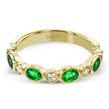 This lovely 18k yellow gold band is perfect for stacking but can also stand on its own. Beautiful green emeralds are paired with .15 ctw of diamonds.