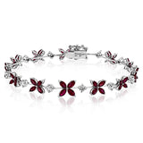 This bracelet charms with a floral design set with 3.58 ctw of rubies and .96 ctw of white diamonds.