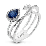 This modern 18k white gold ring features a crossover design set with a .42 ct blue sapphire, .12 ctw of pear shaped diamonds, and .20 ctw of round diamonds.