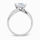 This sparkling modern white gold engagement ring and wedding band set features an eye-catching twisted design accented by .22 ctw of shimmering round cut white diamonds.