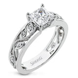 A delicate floral design highlights this vintage style engagement ring accented by .09 ctw of shimmering round cut white diamonds.