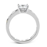 A delicate floral design highlights this vintage style engagement ring accented by .09 ctw of shimmering round cut white diamonds.
