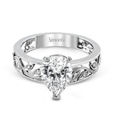 A delicate floral design highlights this vintage style engagement ring accented by .09 ctw of shimmering round cut white diamonds.