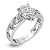 A delicate floral design highlights this vintage style engagement ring accented by .09 ctw of shimmering round cut white diamonds.