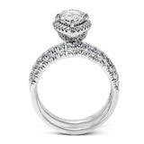 This elegant classic white gold halo engagement ring and band is set with .78 ctw of sparkling round cut white diamonds.