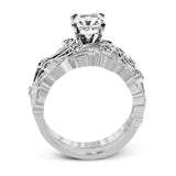 This delicate floral inspired white gold engagement ring and wedding band set is accentuated with .28 ctw shimmering round cut white diamonds.