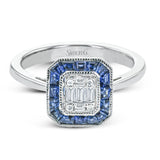 This white gold ring recalls the charm of a past era with a halo of custom-fitting sapphires surrounding a mosaic of .18 ctw diamonds.