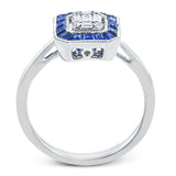 This white gold ring recalls the charm of a past era with a halo of custom-fitting sapphires surrounding a mosaic of .18 ctw diamonds.