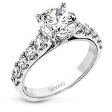 A beautiful row of .86 ctw of significant diamonds leads up to the center stone in this timeless engagement ring design.