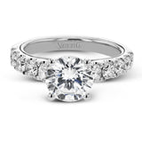 A beautiful row of .86 ctw of significant diamonds leads up to the center stone in this timeless engagement ring design.