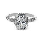 Classic and elegant, this white gold ring sparkles with .40 ctw of round white diamonds framing its oval shaped centerpiece.