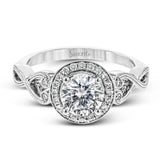 This remarkably beautiful white gold ring features intricate milgrain details alongside a lovely halo of .06 ctw of round white diamonds.