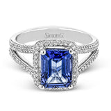 This splendid white gold ring features a delicate split shank and halo, set with .46 ctw of round white diamonds, framing a lovely 2.71 ctw emerald cut tanzanite.