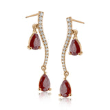2.07 ctw of elegant ruby teardrops are complemented by .16 ctw of white diamonds in these opulent, glamorous white gold earrings