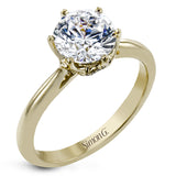 This 18k white gold engagement ring looks deceptively simple at first, but reveals its intricacy upon closer inspection. Accents of .05 ctw of diamonds decorate the sides of the six-prong center stone setting, creating a stunning effect.