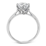 This 18k white gold engagement ring looks deceptively simple at first, but reveals its intricacy upon closer inspection. Accents of .05 ctw of diamonds decorate the sides of the six-prong center stone setting, creating a stunning effect.