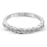 This vintage inspired 18k white gold ring contains .11 ctw of round white diamonds in a delicate swirling design. Perfect for stacking.