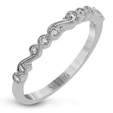 This vintage inspired 18k white gold ring contains .11 ctw of round white diamonds in a delicate swirling design. Perfect for stacking.