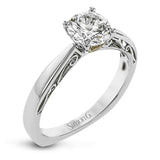 This sleek, elegant white gold ring features delicate filigree detailing to accentuate its single, central stone.