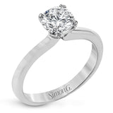 This sleek, unadorned white gold ring provides an elegantly modern setting for a single, central stone.