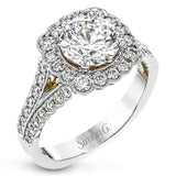 This engagement ring has a unique design with a halo of bezel set diamonds. The setting contains .81 ctw of white diamonds.