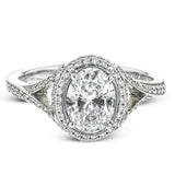 Elegant and sophisticated, this white gold ring's delicate halo and split shank glitter with .28 ctw of round white diamonds to highlight an oval shaped center stone.